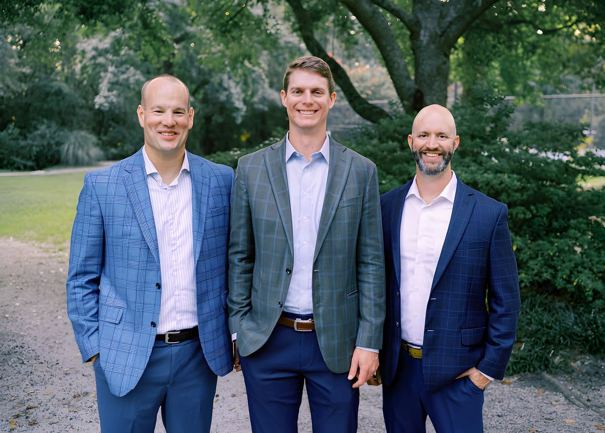 The three partners of Grove Wealth Group standing together outdoors